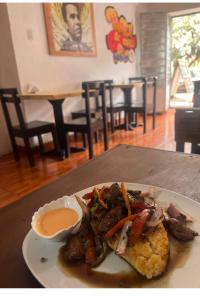 a plate of food with meat and vegetables on a table at Cusco House Inn Hostel in Cusco