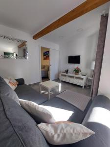 een woonkamer met een bank en een tv bij CASA ANTONIO Pasillo al Mar 40A in Costa Teguise