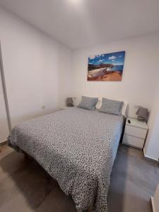 a bedroom with a bed and a painting on the wall at CASA ANTONIO Pasillo al Mar 40A in Costa Teguise +18 photos
