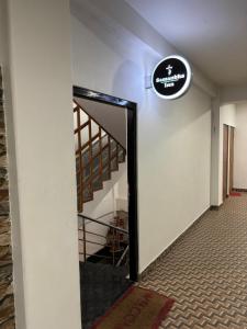 a hallway with a staircase with a sign on the wall at Samanbha Guest House in Shillong +1 photo