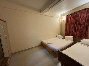 a small room with two beds and a window at Samanbha Guest House in Shillong