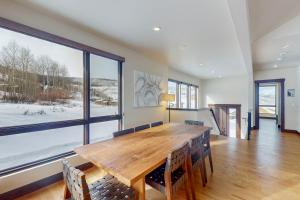 a dining room with a wooden table and a large window at A Slice of Silverthorne in Silverthorne