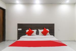 Cette chambre comprend un lit avec des oreillers rouges et blancs. dans l'établissement OYO Hotel Galaxy, à Faridabad