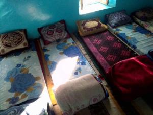 um grupo de almofadas e cobertores num quarto em دارالضيافة git atlas em Megdaz