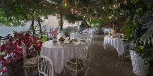 a restaurant with white tables and chairs and plants at Il Barilotto in Positano