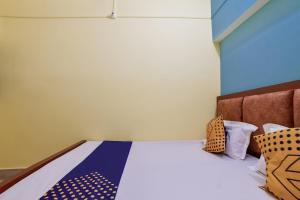 a bedroom with a bed with a blue and white bedspread at SPOT ON Luv-kush Inn in Bankipur