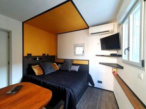 a small bedroom with a bed and a table at Apartment MiniSteel Loft Brotteaux Part-Dieu in Lyon