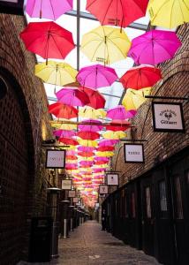 un montón de coloridos paraguas colgando de un edificio en Camden Cocoon, 2' from Tube up to 4, en Londres