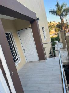una casa con una puerta blanca y una escalera en Apartamento la Familia en Santa Bárbara de Samaná