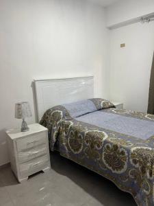 1 dormitorio con cama y mesita de noche en Apartamento la Familia en Santa Bárbara de Samaná
