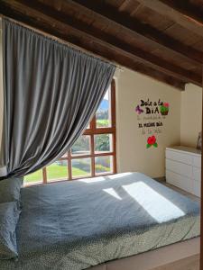 um quarto com uma cama e uma janela em Eguzkitza em Iturriotz