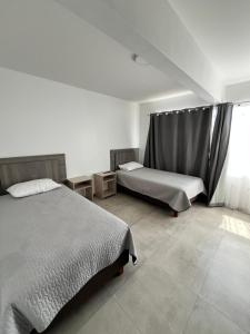 1 dormitorio con 2 camas y ventana en Hotel Santa María en Iquique