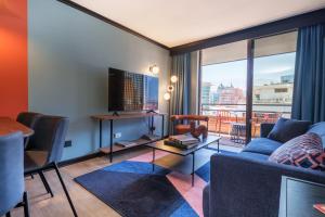a living room with a couch and a tv at APT Serviced Apartments Santiago in Santiago