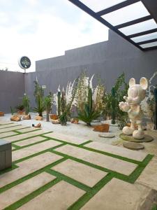 a courtyard with plants and a teddy bear statue at Hotel Suites Lounge La Viga in Cali