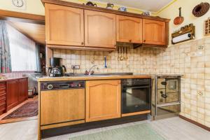 a kitchen with wooden cabinets and a sink at Ferienhaus am Tullnberg in Mörtelsdorf +18 photos