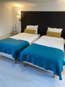 twee bedden naast elkaar in een slaapkamer bij La suite cosy de Julie , 2 pièces 3 lits parking privé Résidence Cosyade in Bourbourg