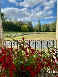 un montón de flores rojas en una valla en Château La Bainerie, en Tiercé