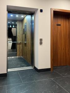 korytarz z dwoma windami i drewnianymi drzwiami w obiekcie Kras-Resort Apartament 301 z widokiem na góry, prywatnym jacuzzi na tarasie i sauną w Szklarskiej Porębie