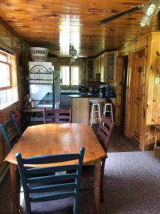 uma cozinha e sala de jantar com uma mesa de madeira e cadeiras em Camp Overlook - Big Moose Lake, NY 