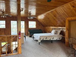 um quarto com uma cama num chalé de madeira em Camp Overlook - Big Moose Lake, NY 