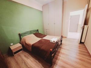 - une chambre avec un lit dans une pièce aux murs verts dans l'établissement Αθηναϊκό Διαμέρισμα 5, à Athènes