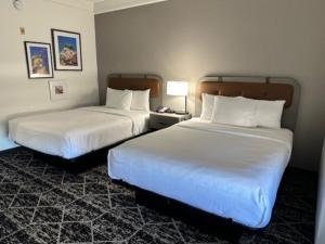 a hotel room with two beds and a lamp at La Quinta by Wyndham Houston Bush IAH South in Houston