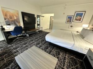 um quarto de hotel com uma cama, uma secretária e uma televisão em La Quinta by Wyndham Houston Bush IAH South em Houston