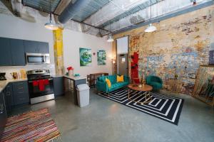 孟菲斯的住宿－Cozy Luxurious Loft in Downtown Memphis，厨房以及带沙发和桌子的客厅。