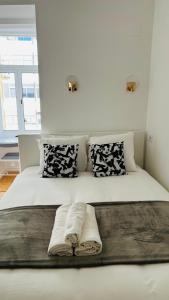 a white bed with pillows on top of it at Suites Luciano Cordeiro in Lisbon