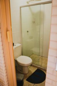 a bathroom with a toilet and a glass shower at Casa da Cacaia e do Henrique in Rio de Janeiro