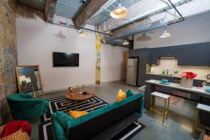 a living room with two green chairs and a table at Cozy Luxurious Loft in Downtown Memphis in Memphis