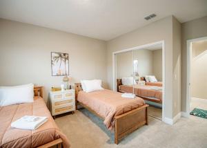 a bedroom with two beds and a mirror at OCEAN VIEW - Retro Arcade - 3 bedrooms in Daytona Beach Shores