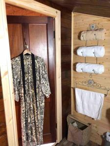 a cabin bathroom with a robe and towels at Unique Tiny House near 3 Peaks - The ZedShed in High Bentham