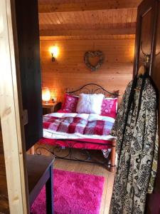 a bedroom with a bed with pink pillows at Unique Tiny House near 3 Peaks - The ZedShed in High Bentham