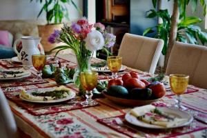 een tafel met borden eten en bloemen erop bij Casa Flor de Sol - Natural Park Aracena in Navahermosa