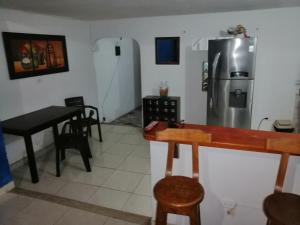 a kitchen with a refrigerator and a table and chairs at Casa lowcost relajación total! in La Dorada