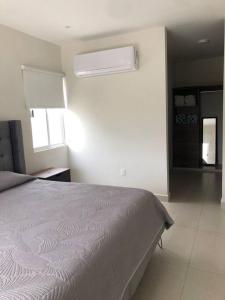 a white bedroom with a bed and a window at Velamar, casa con alberca y asador in Miramar