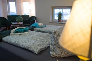 two beds in a room with chairs and windows at Hotel Villa Elisabeth in Ostseebad Sellin