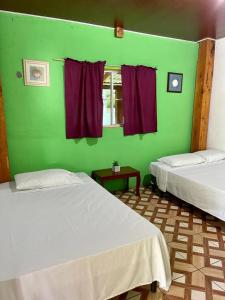 a room with two beds and a green wall at RANCHO BOLMAR. Playa Metalio. Sonsonate. in Acajutla