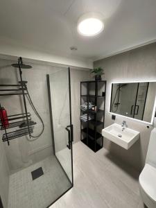 a bathroom with a shower and a sink at Sentral pen leilighet 