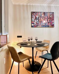 a dining room with a table and chairs and a painting at BaMo Studio - city living arkaden in Klagenfurt