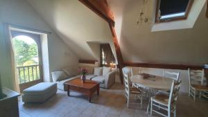 a living room with a couch and a table at Gîte Bellevue - Domaine de la chapelle en Corrèze in La Chapelle-aux-Brocs