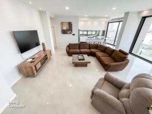 a living room with couches and a flat screen tv at DEPARTAMENTO DE LUJO in Santa Cruz de la Sierra