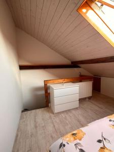 a attic room with a bed and a dresser in it at Bequemes und helles Einfamilienhaus mit Garten in Weil am Rhein