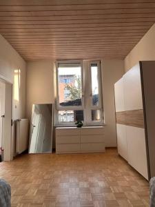 an empty room with a large window and a kitchen at Bequemes und helles Einfamilienhaus mit Garten in Weil am Rhein