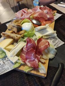 een bord met vlees en kaas op een tafel bij Locanda LaRotonda in Villa Verucchio