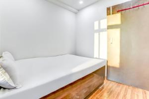 a white bed in a room with a window at SPOT ON Plaza Guest House in Patna