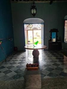 Una habitación con una mesa con un pájaro. en Casa Hacienda Estrada, en Campeche