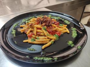 a black plate of food with fries and broccoli at Locanda LaRotonda in Villa Verucchio