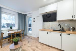 una cucina con armadi bianchi, un tavolo e una sala da pranzo di Prime Apartments - Studio a Sopot